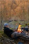 Sweden, Skane, Man lying down by campfire
