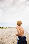 Sweden, Gotland, Shirtless boy (8-9) with kite at beach