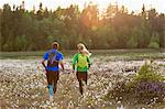 Sweden, Vasterbotten, Grossjons Nature Reserve, Man and woman running in meadow