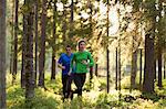 Sweden, Vasterbotten, Grossjons Nature Reserve, Man and woman running in forest
