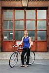 Germany, Berlin, Woman standing by bicycle