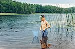 Sweden, Smaland, Mortfors, Kappemalagol, Boy (8-9-) wading and fishing