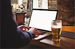 Man using laptop at bar counter