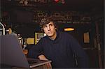 Man with laptop at bar counter