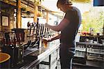 Bar tender filling beer from bar pump at bar counter