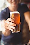 Close-up of man holding glass of beer at bar