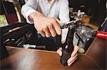 Close-up of bartender opening a beer bottle at bar counter