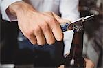 Close-up of bartender opening a beer bottle at bar counter