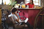 Man sitting on chair and using laptop in bicycle shop