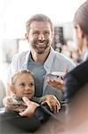 Father and daughter with airplane tickets at airport check-in counter