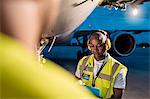 Air traffic control ground crew working under airplane on airport tarmac