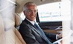 Portrait smiling businessman riding in back seat of town car