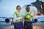 Portrait confident air traffic control ground crew workers near airplane on airport tarmac