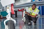 Ground crew worker with clipboard checking airplane