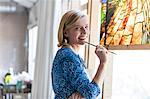 Portrait smiling artist working on stained glass