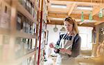 Stained glass artist examining glass pieces in studio