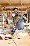 Stained glass artists examining glass pieces in studio