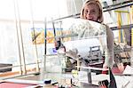 Portrait smiling stained glass artist lifting glass in studio