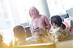 Business people clapping for businesswoman leading meeting in office