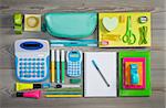 Stationery and student equipment perfectly tidy on wooden surface.