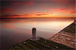 Glorious red sunrise skies and water reflections from one of the jetties at Berkeley Vale on the Central Coast of NSW Australia