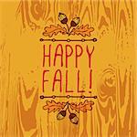 Hand-sketched typographic element with acorns and text on wooden background. Happy Fall