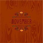 Hand-sketched typographic element with mushroom, berries and text on wooden background. November