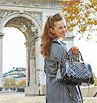 Stylish autumn in Paris. Portrait of happy young fashion-monger in trench coat in Paris, France