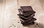 Dark Chocolate Bars Stack on Wooden Table. Place for Text.