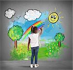 Creative little girl colors with a big pencil a green landscape