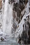 Frozen beautiful waterfall in winter. Icicles and mountain river.