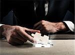 Businessman complete a puzzle inserting last piece