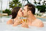 Young couple inside a jacuzzi dating and toasting