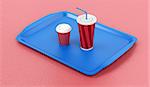 Plastic tray with coffee cup and soft drink on red table