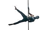 Athletic pole dancer with horrific body-art hangs horizontal on a pylon in the studio on the white background. He wears black pants and looks into the camera. His legs are outstretched to the sides.