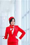Smiling stewardess with a suitcase at airport
