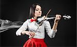 Attractive  woman playing the violin on a black background and smoke