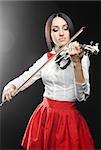 Beautiful woman playing the violin on a black background closing her eyes