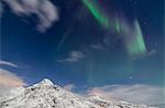 Northern lights (Aurora Borealis) and stars light up the snowy peaks, Vareid, Flakstad, Nordland, Lofoten Islands, Northern Norway, Scandinavia, Europe