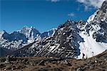 A trekker in the Everest region on the way up to Everest Base Camp seen here walking in front of Cholatse, Khumbu Region, Nepal, Himalayas, Asia