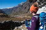 A woman trekking in the Langtang valley in Nepal rests near a chorten, Langtang Region, Himalayas, Nepal, Asia
