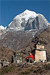 A trekker stops beside a chorten to admire the views on the way to Everest Base Camp with views of Taboche in the distance, Khumbu Region, Himalayas, Nepal, Asia