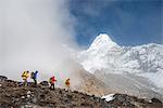 A team of four climbers make their way to Ama Dablam Base Camp, the 6856m peak seen in the distance, Khumbu Region, Himalayas, Nepal, Asia