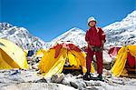 A woman stands by her tent shortly after climbing Everest, Khumbu Region, Himalayas, Nepal, Asia