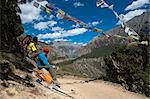 Prayer flags mark a high point in the trail where trekkers are rewarded with their first glimpse of Phoksundo Lake, Dolpa Region, Himalayas, Nepal, Asia