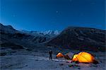 A man standing outside his tent on a cold night in the little explored Juphal Valley in the remote Dolpa region, Nepal, Asia