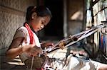 A little girl learns the skill of weaving on a handloom, Chittagong Hill Tracts, Bangladesh, Asia