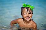 Portrait of a smiling young boy in a swimming pool.