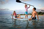 Mother, father and daughter on surfboard