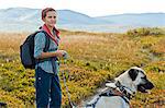 Scandinavia, Sweden, Norrland, Hemavan, young woman hiking with dog in mountains